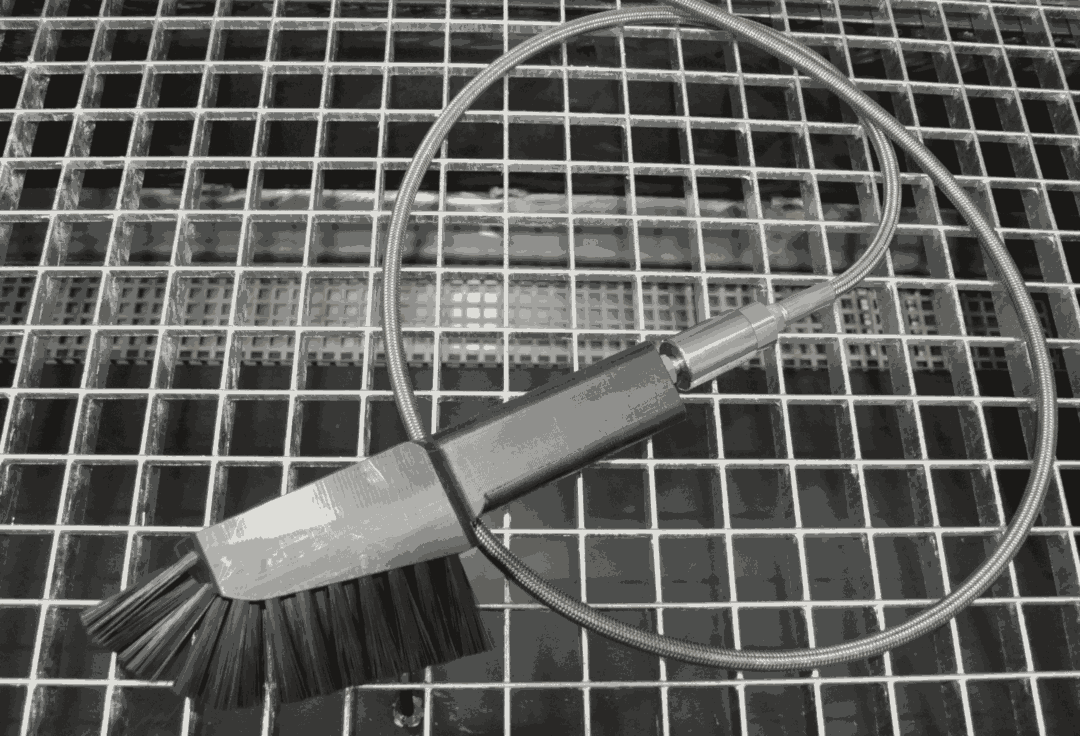 Industrielle Bürste für den Renzmann Handwaschplatz mit Metallschlauch auf Gitterrost