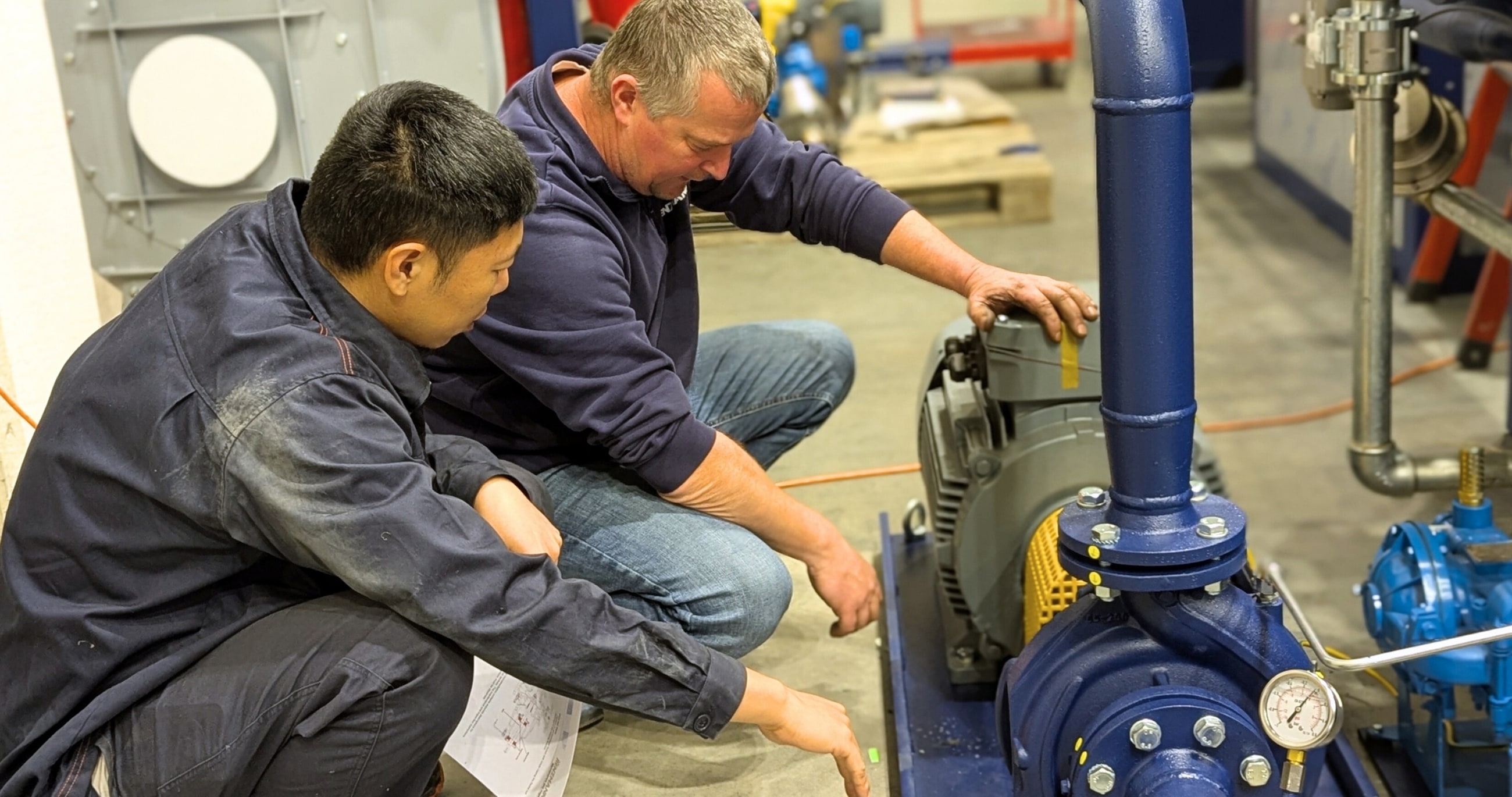 Techniker prüfen industrielle Pumpe in Werkstatt